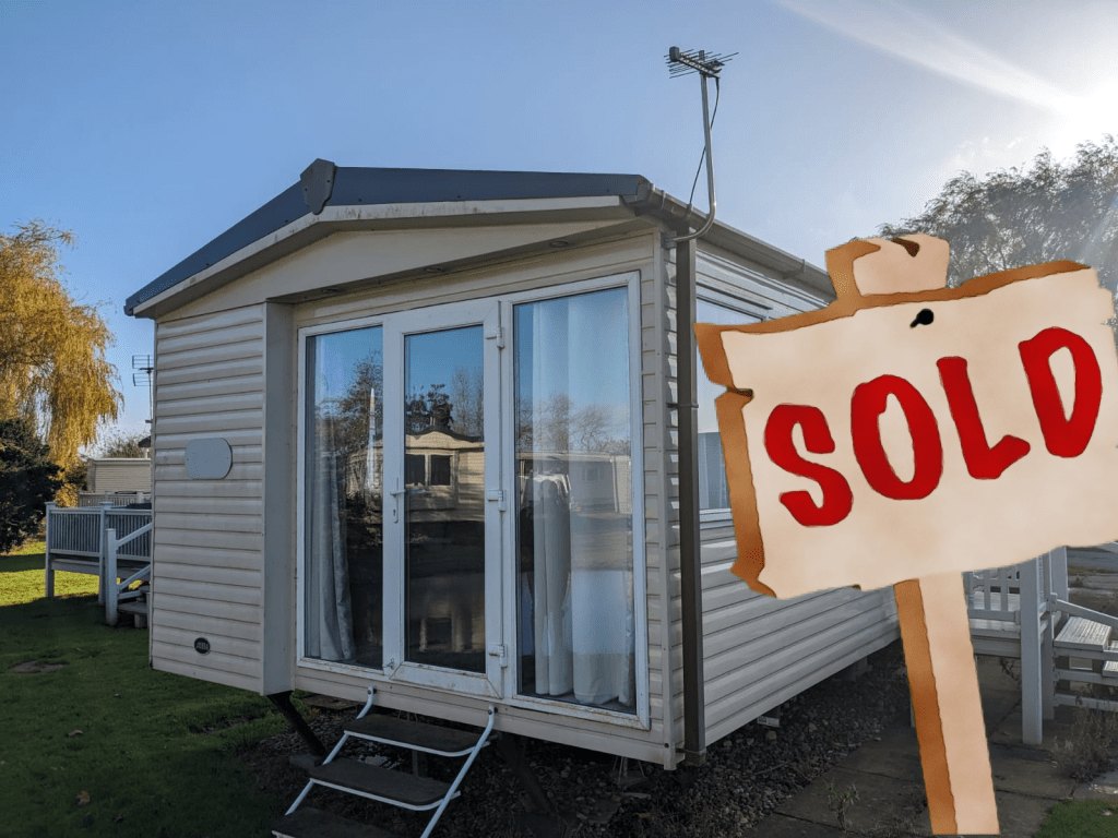 An ABI St David static caravan with patio doors and steps, with the original website's SOLD sign
